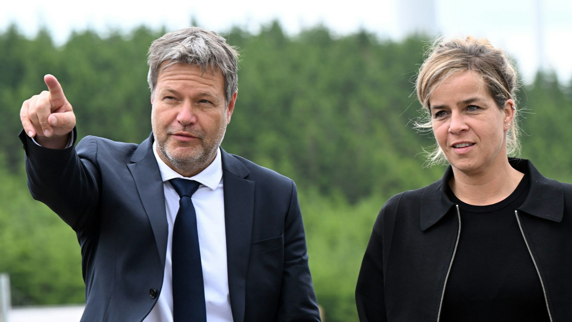 Robert Habeck, Bundeswirtschaftsminister, und NRW-Wirtschaftsministerin Mona Neubaur (beide Grüne), stehen vor Windrädern zur Stromerzeugung.