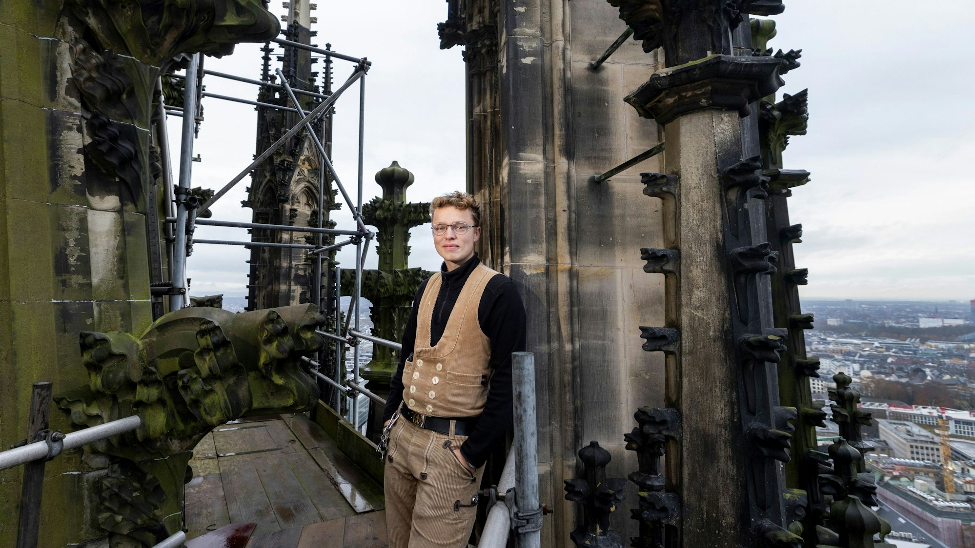Steinmetz Ludger Weichhaus von der Kölner Dombauhütte auf dem Nordturm des Doms. Hinter ihm die erneuerte Spitze einer Fiale (Ziertürmchen)