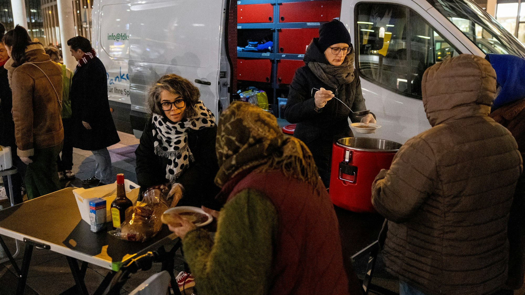 Esra Peker (links) und Nina Faulhaber verteilen Brot und Eintopf