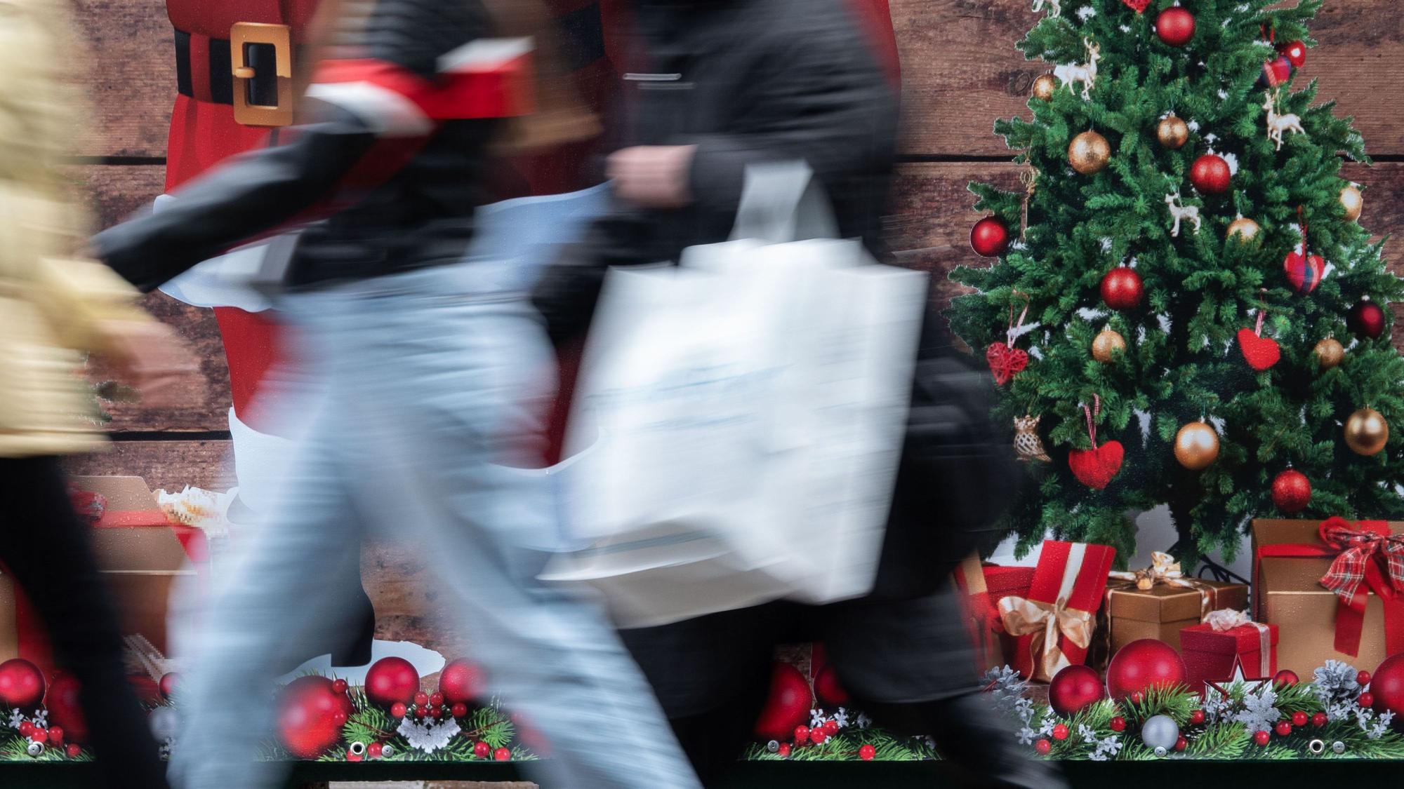 ARCHIV - 24.11.2023, Baden-Württemberg, Stuttgart: Passanten gehen an einem weihnachtlich geschmückten Verkaufsstand auf der Königstraße in Stuttgart vorbei. (zu dpa: «Mehr Geld für Weihnachtsgeschenke - trotz trüber Aussichten») Foto: Anna Ross/dpa +++ dpa-Bildfunk +++