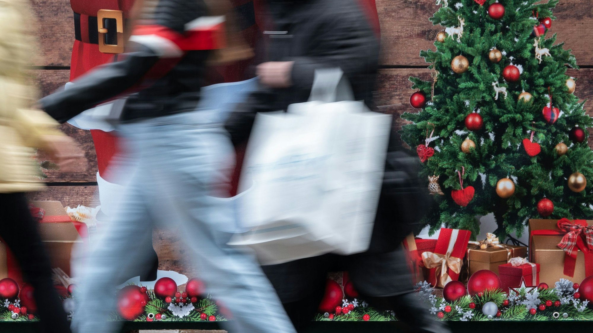 ARCHIV - 24.11.2023, Baden-Württemberg, Stuttgart: Passanten gehen an einem weihnachtlich geschmückten Verkaufsstand auf der Königstraße in Stuttgart vorbei. (zu dpa: «Mehr Geld für Weihnachtsgeschenke - trotz trüber Aussichten») Foto: Anna Ross/dpa +++ dpa-Bildfunk +++