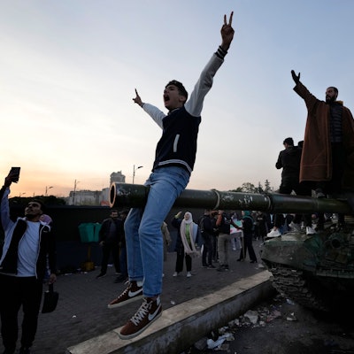 Syrische Bürger stehen auf einem Panzer der Regierungstruppen, und feiern die Übernahme der Stadt durch die Aufständischen.