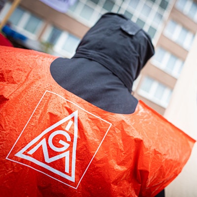 Ein VW-Beschäftigter nimmt an einer Kundgebung der IG Metall vor dem Hotel, welches für die fünfte Tarifrunde dient, teil.