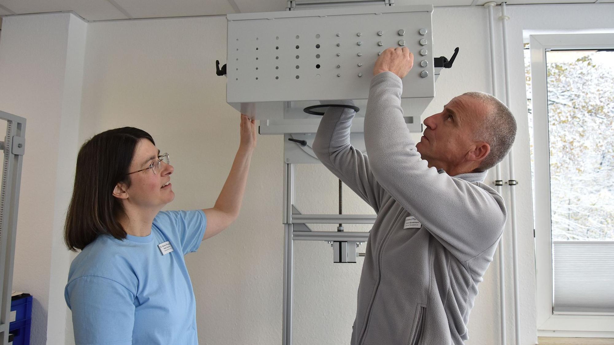 Der Leiter des Therapiezentrums, Ulrich Häussermann, demonstriert unter den kritischen Blicken der Bereichsleiterin Ergotherapie, Heike Oppenberg, wie Über-Kopf-Arbeiten trainiert wird.