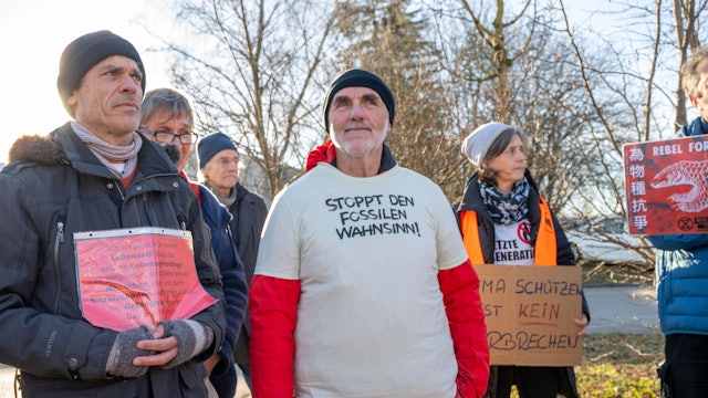Karl Braig, Aktivist der Letzten Generation, steht vor Beginn seines Haftantritts vor der Justizvollzugsanstalt Kempten zwischen Teilnehmern einer Mahnwache für ihn.