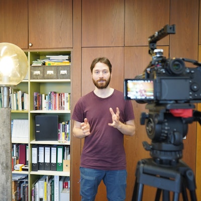 Das Foto zeigt einen jungen Mann vor der Kamera.