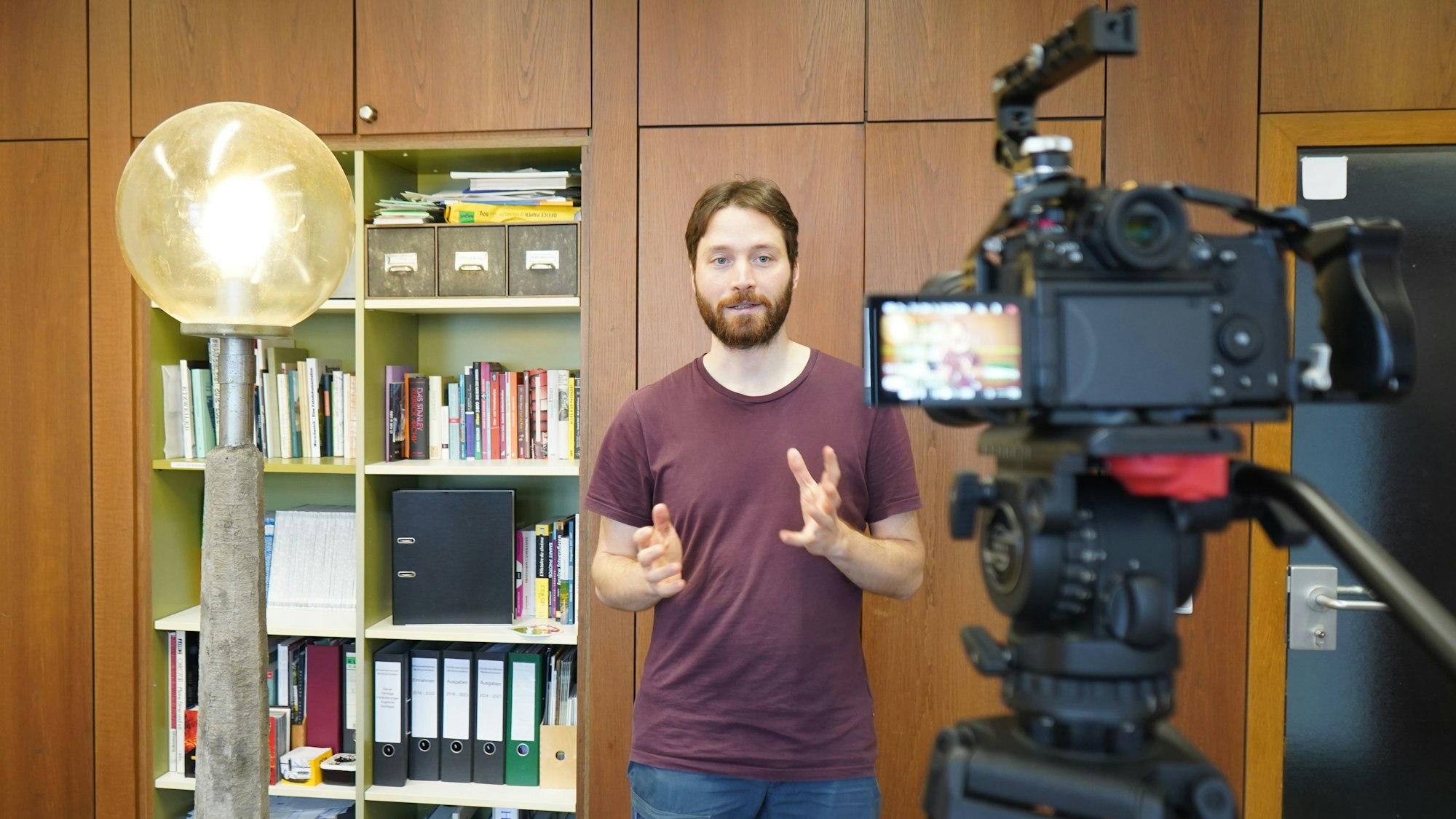 Das Foto zeigt einen jungen Mann vor der Kamera.