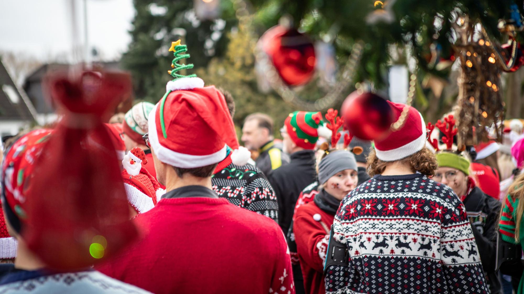 Sportler in hässlichen Weihnachtspullis warten auf den Start.