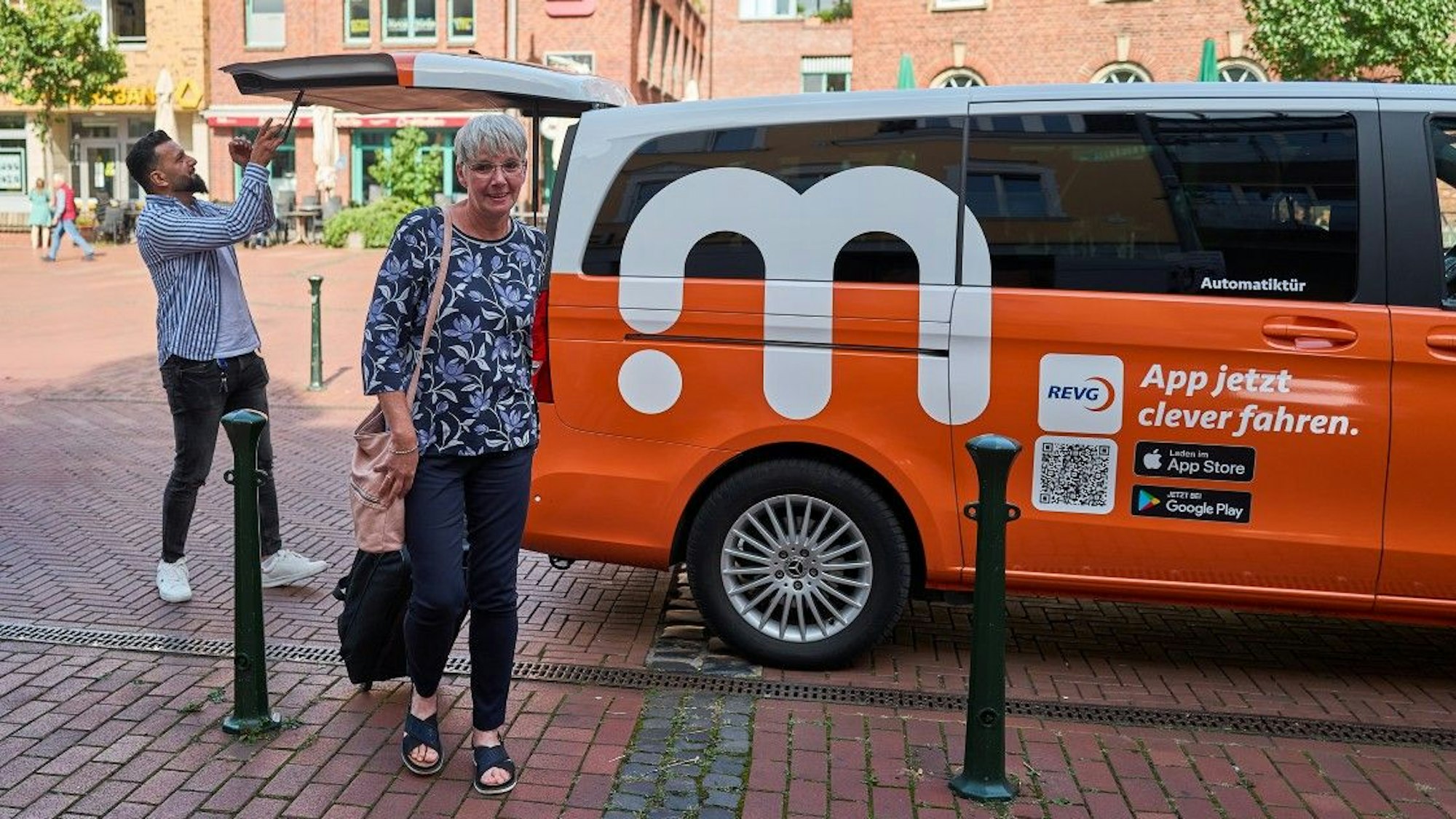 Eine Frau ist gerade aus einem Elektro-Kleinbus ausgestiegen.