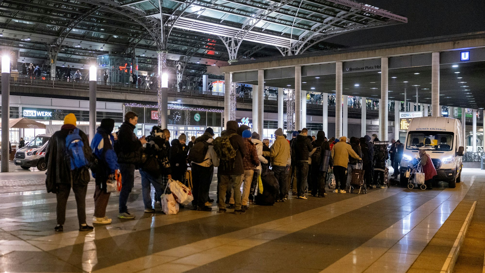 Eine lange Menschenschlange steht vor dem Kältebus