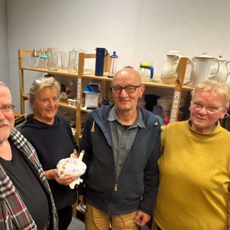 Auf dem Bild sind zwei Männer und zwei Frauen zu sehen, die im Sozialwarenhaus arbeiten.