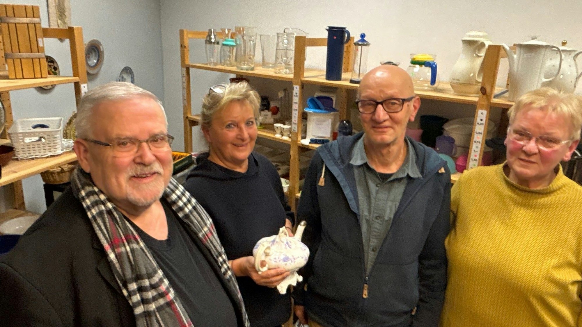 Auf dem Bild sind zwei Männer und zwei Frauen zu sehen, die im Sozialwarenhaus arbeiten.