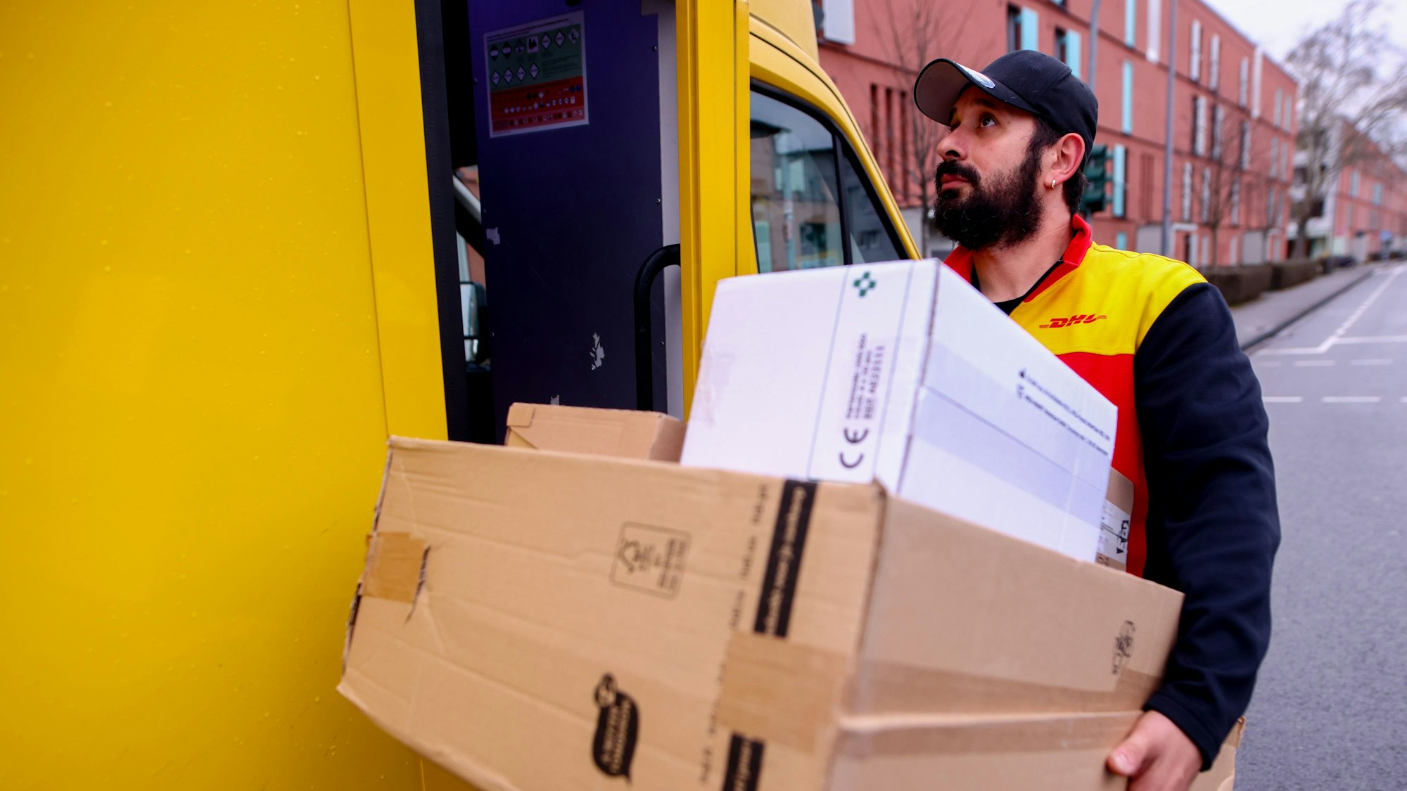 Paketfahrer Calogero Santamaria trägt mehrere Pakete zugleich