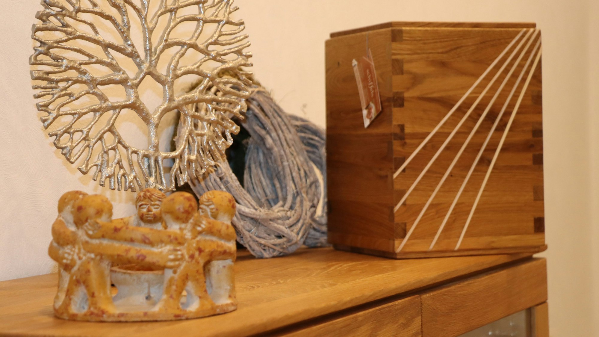 Auf dem Bild sind Urnen aus Holz zu sehen, die auf einem Tisch stehen.