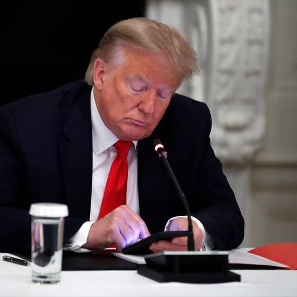 Während eines runden Tisches schaut Donald Trump auf sein Handy. (Archivbild)