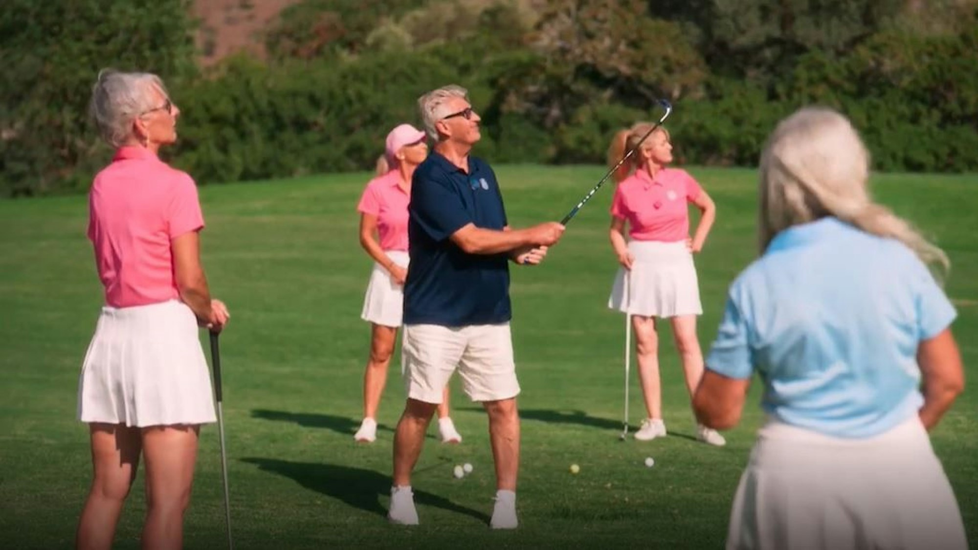 Golden Bachelor Franz zeigt den Kandidatinnen, wie man einen Golfschläger richtig schwingt.