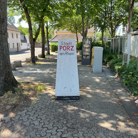 Ab 1. Januar 2025 gehört die ehemalige Stadt Porz am Rhein, wie dieser Stein im Stadtteil Langel unweit des Eulenplatzes zeigt, seit 50 Jahren zu Köln.