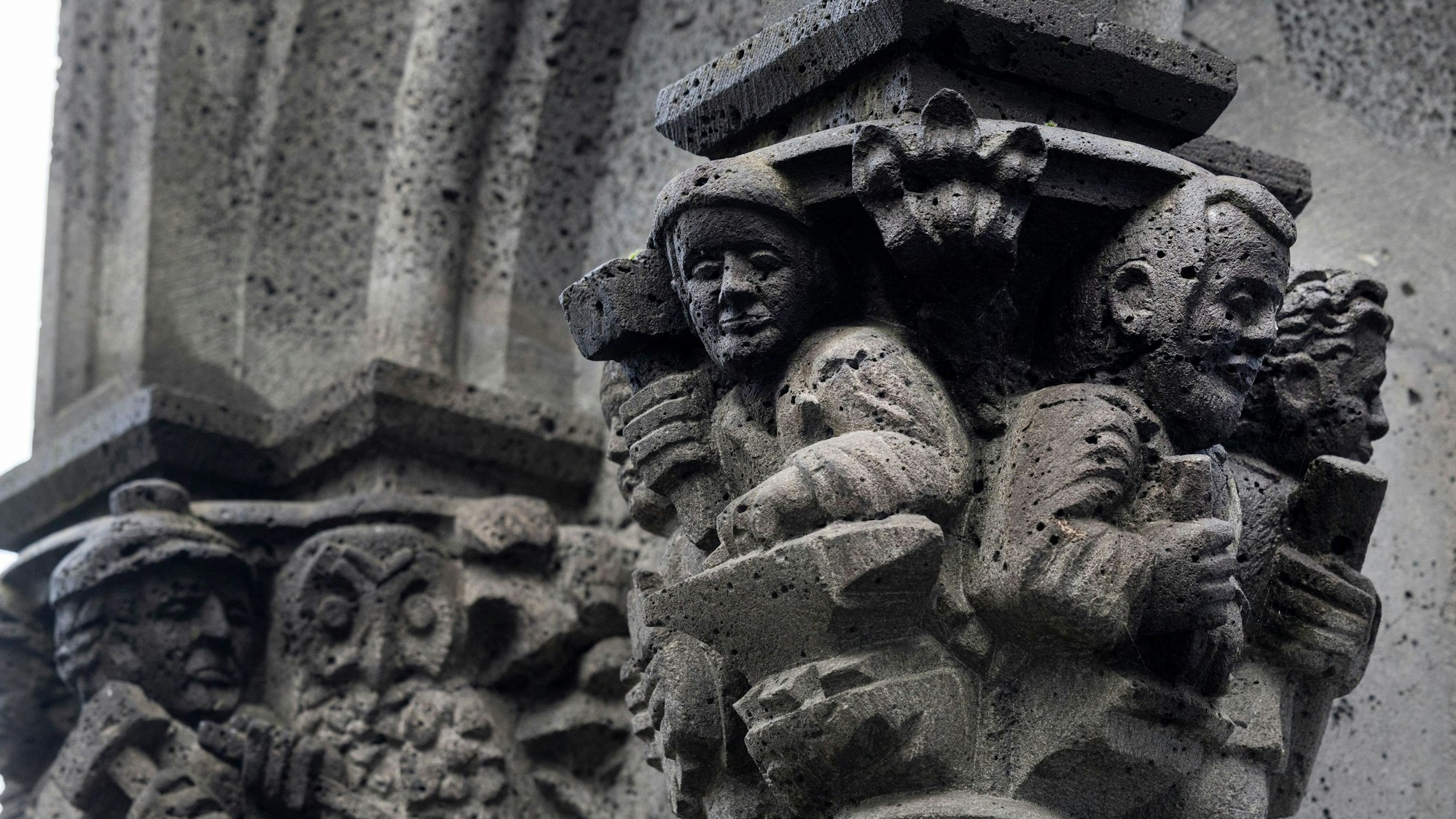 Domschmied Alois Olmscheid (Figur Mitte, mit Hammer und Amboss) wurde von seinen Kollegen aus der Dombauhütte als Konsolenfigur an der Nordseite des Kölner Doms verewigt.