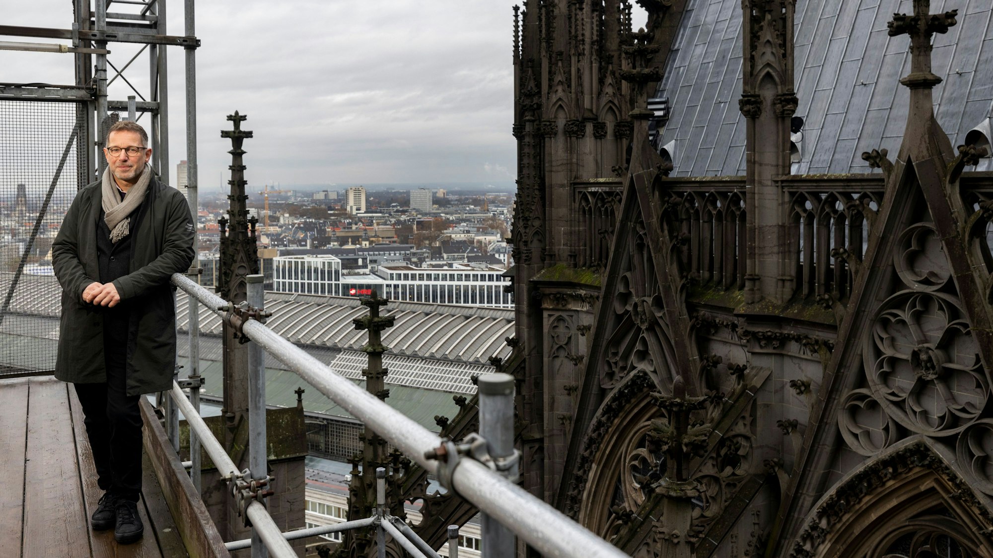 Dombaumeister Peter Füssenich auf der Gerüstbrücke des Kölner Doms. Rechts im Hintergrund die Ziertürme, an denen sich Darstellungen von Mitarbeitern der Dombauhütte befinden.
