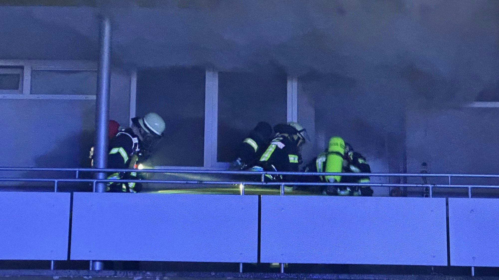 Einsatzkräfte der Feuerwehr Bonn dringen unter Atemschutz in die brennende Wohnung vor.