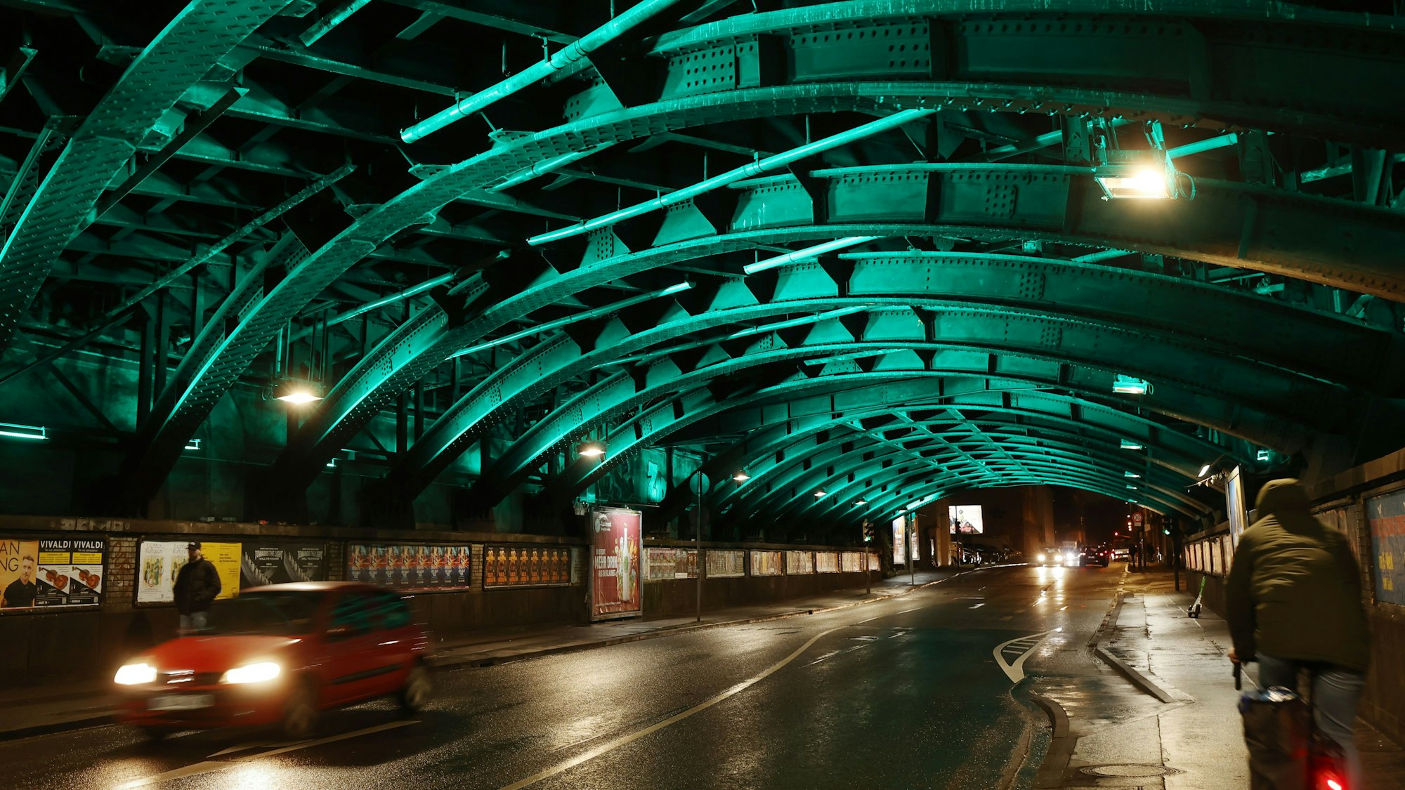 Die Bahnunterführung wird in der Dunkelheit durch türkisfarbenes Licht erhellt