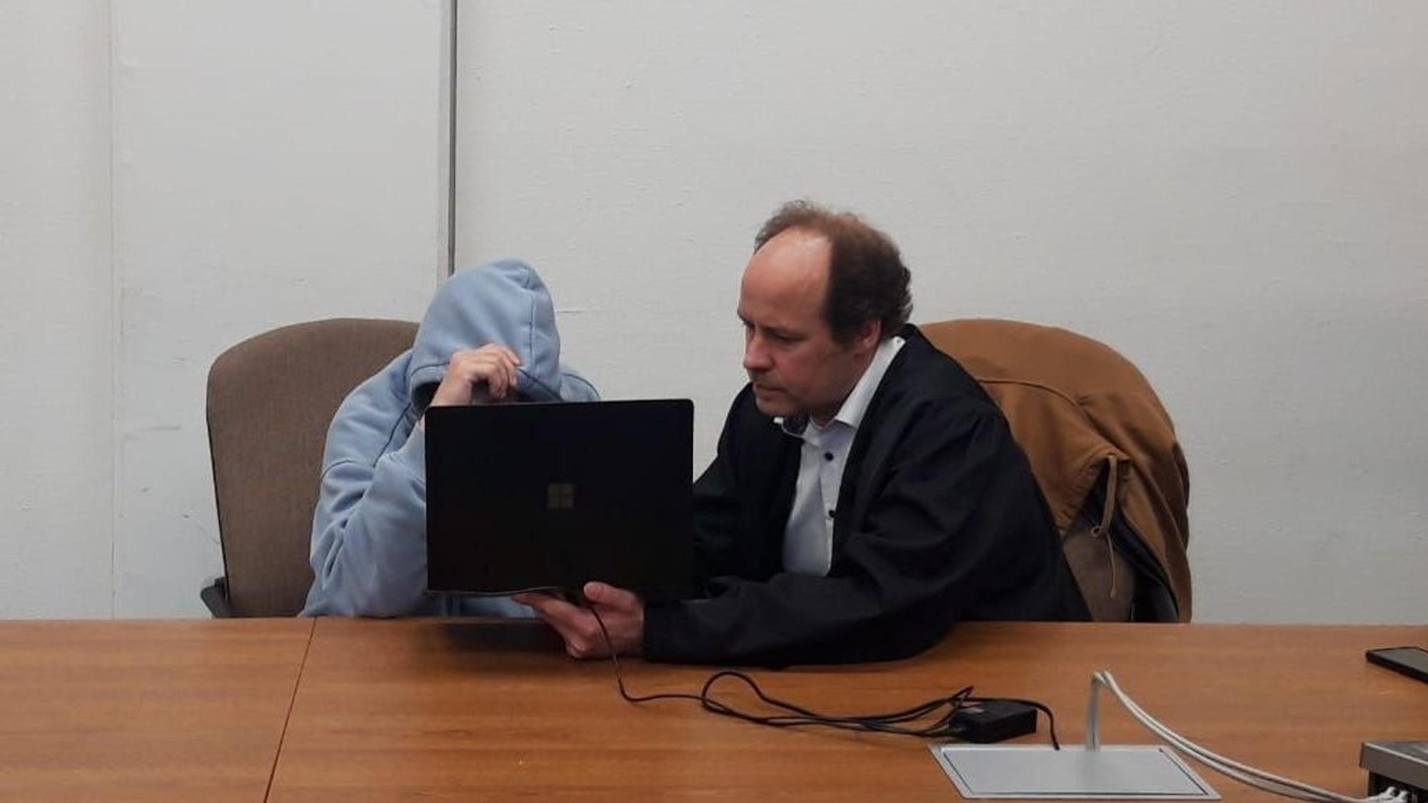 Auf dem Foto sind der Angeklagte und sein Anwalt Markus Heinrichs in einem Gerichtssaal zu sehen.