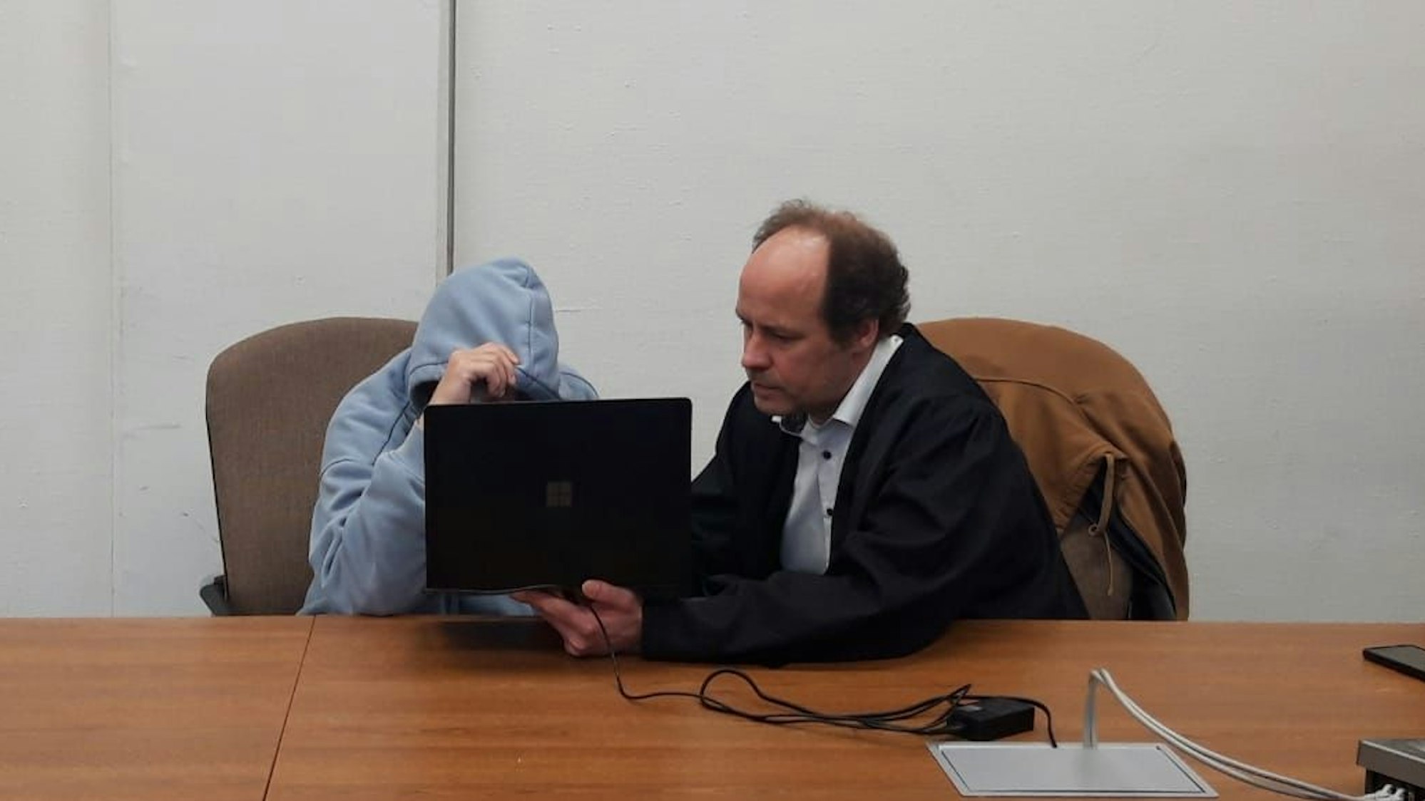 Auf dem Foto sind der Angeklagte und sein Anwalt Markus Heinrichs in einem Gerichtssaal zu sehen.