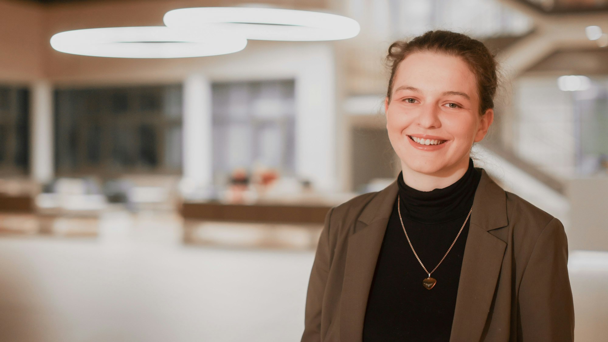 Viktoriia Pelin steht im hell beluchteten Foyer der Uniklinik.