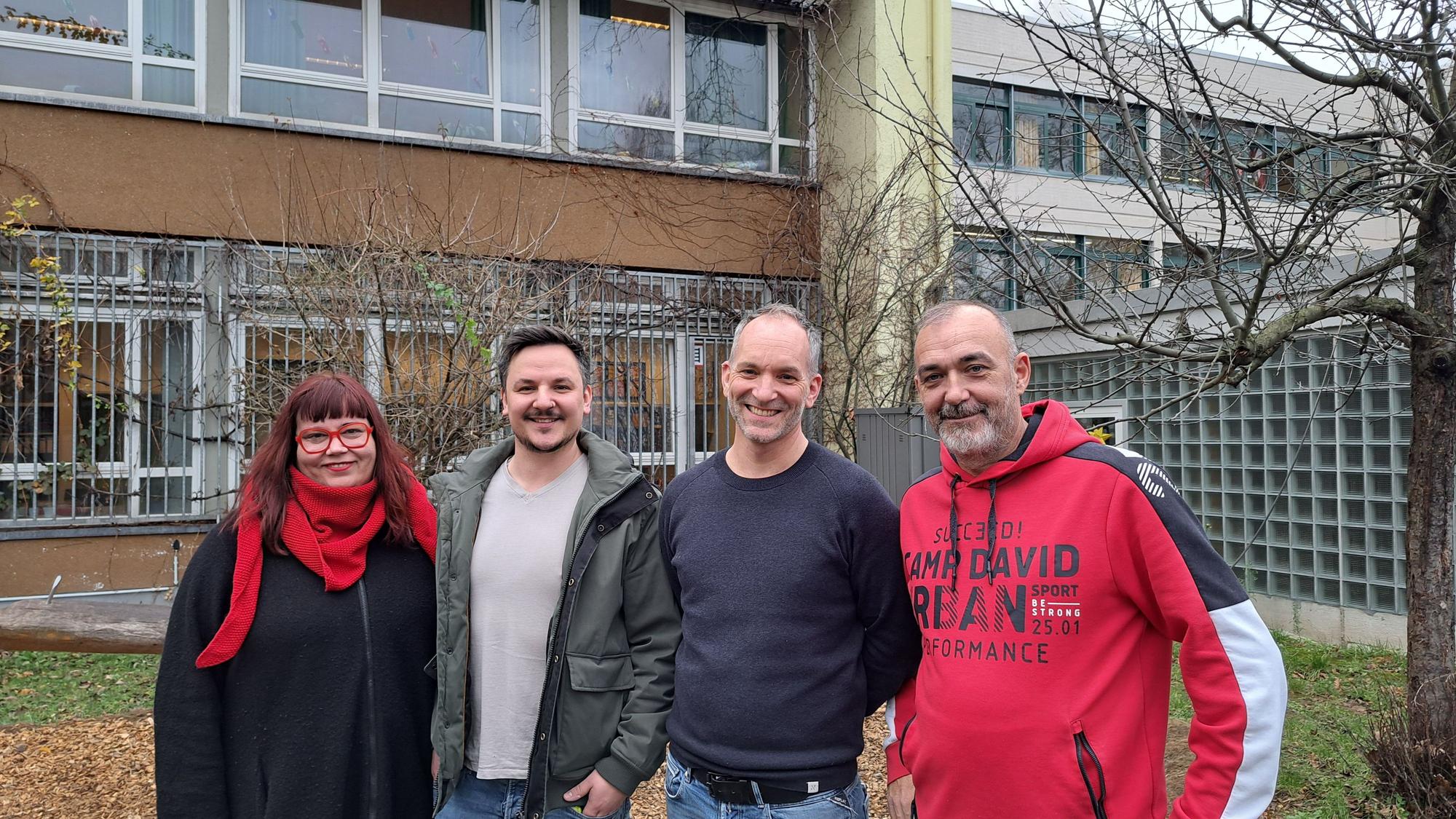 Vier Personen stehen vor einem Schulgebäude nebeneinander. v.l.: Sara Berthon, Konrektorin, Kai Wojtas, Koordinator des Familiengrundschulzentrums, Johannes Köper-Braun, Rektor und Guido Rosenbaum, Hausmeister