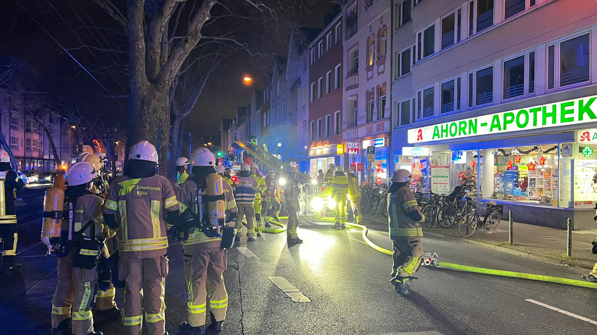 Feuerwehrleute stehen auf der Luxemburger Straße in Köln. Auf Höhe der Hausnummer 285 ist es zu einem Brand gekommen.