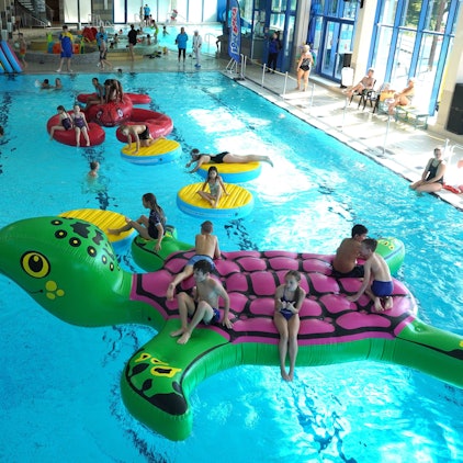 Kinder spielen in einem Schwimmbad.