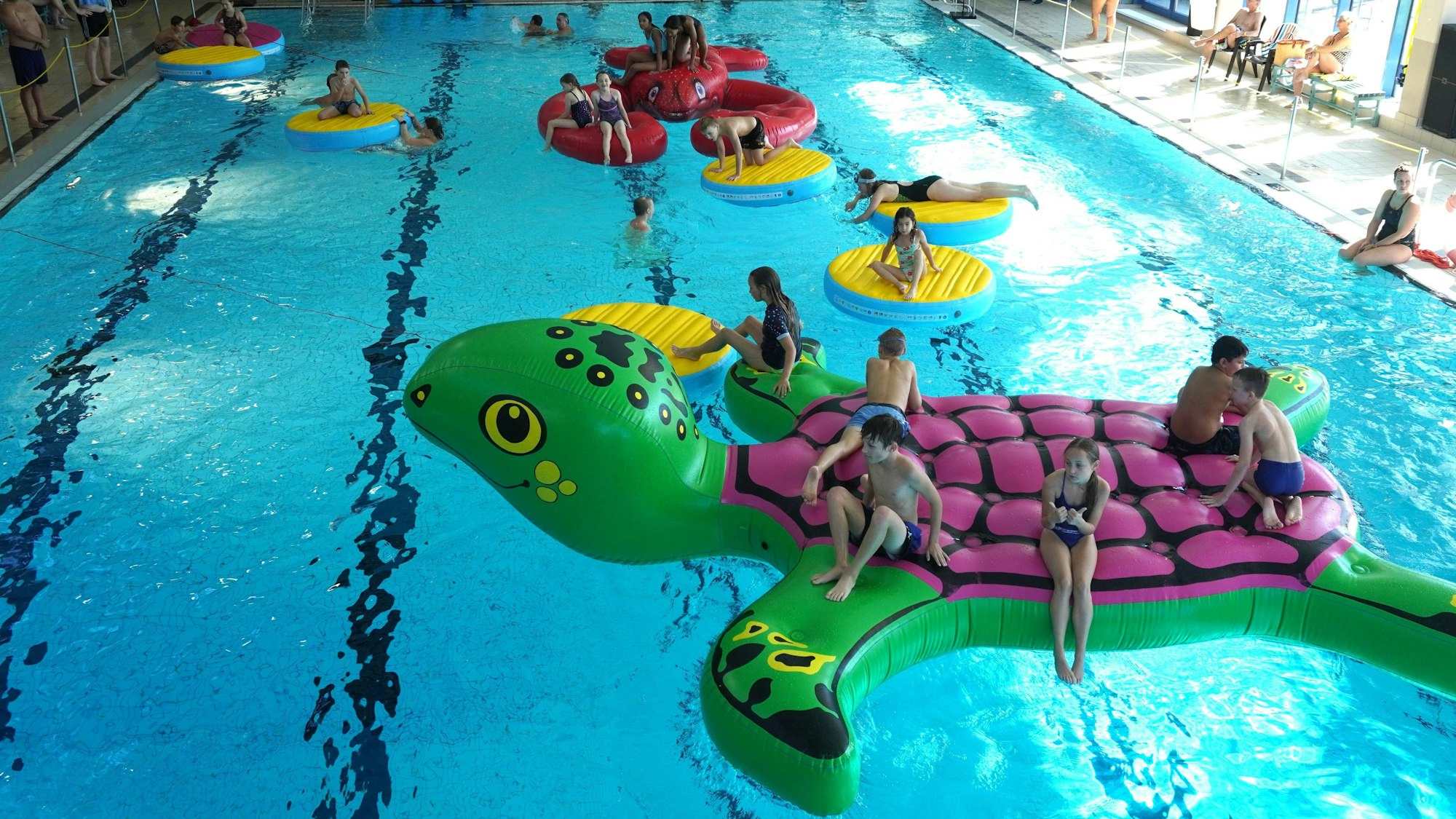 Kinder spielen in einem Schwimmbad.