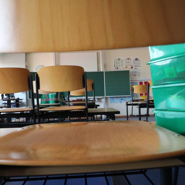 Stühle stehen auf Schultischen in einer Grundschule.