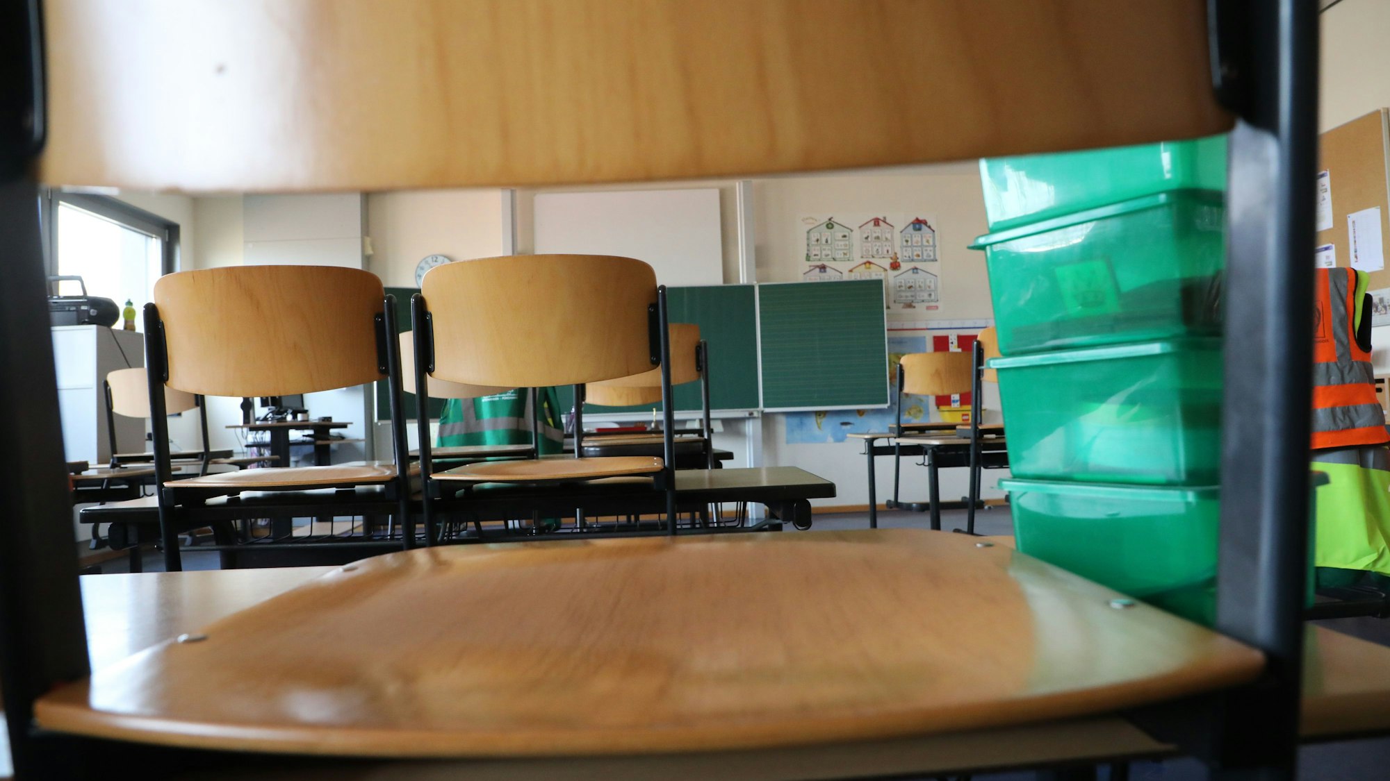 Stühle stehen auf Schultischen in einer Grundschule.