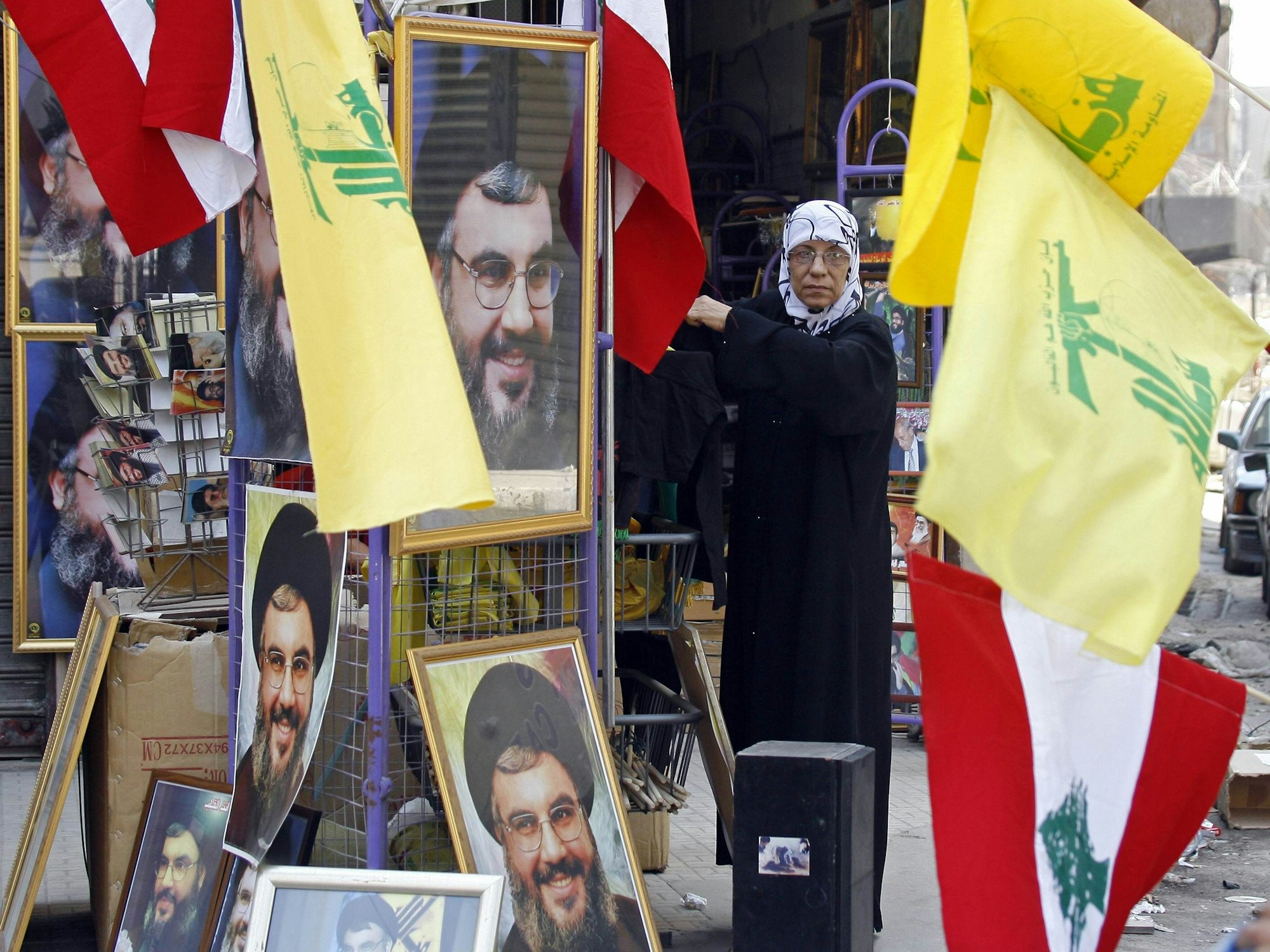 Eine Frau verkauft im Libanon Flaggen der Terrororganisation Hisbollah und ihres mittlerweile getöteten Anführers Sayyed Hassan Nasrallah.