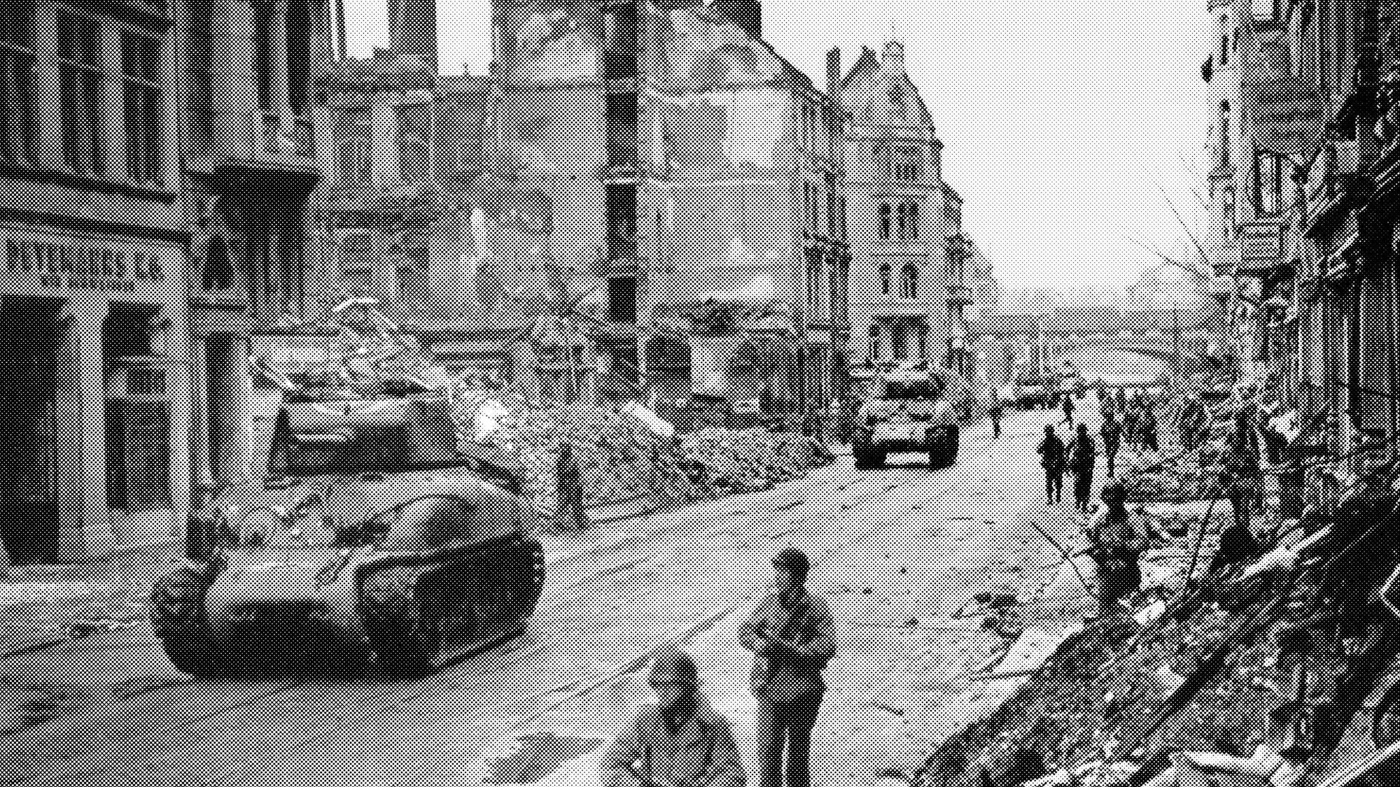 Archivbild von einem Panzer, der durch die zerbombte Stadt fährt