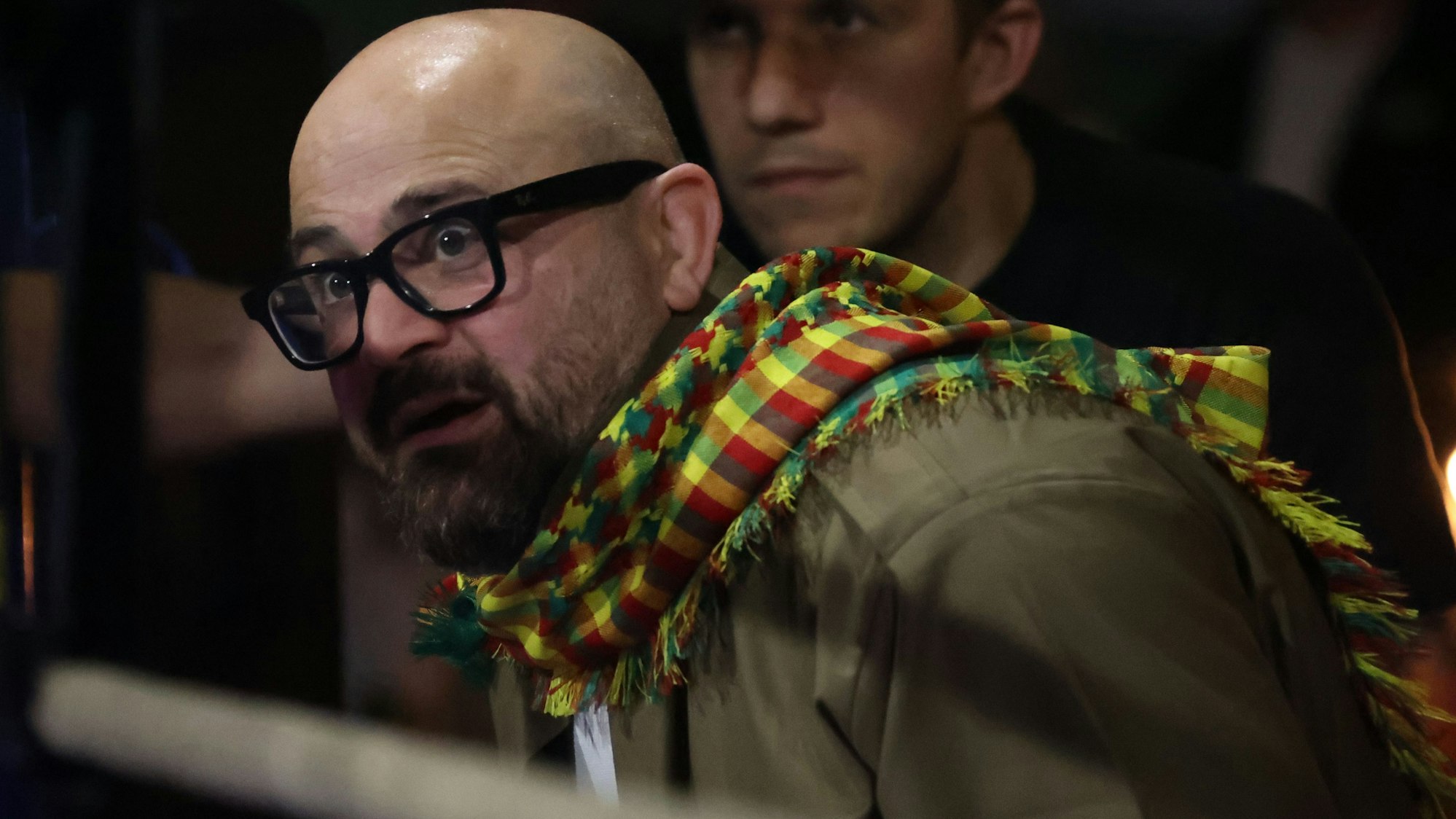 Bakar Barakat schaut mit aufgerissenen Augen in den Ring. Er trägt einen auffällig bunten Schal.