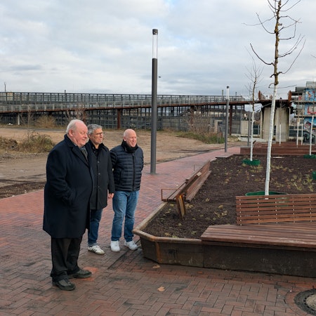 Drei Männer stehen an neu hergerichteten Hochbeeten.