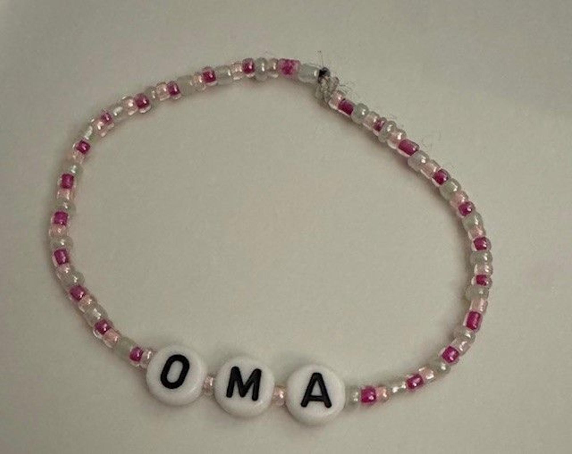 Ein Armband aus Perlen und dem eingewebten Wort Oma