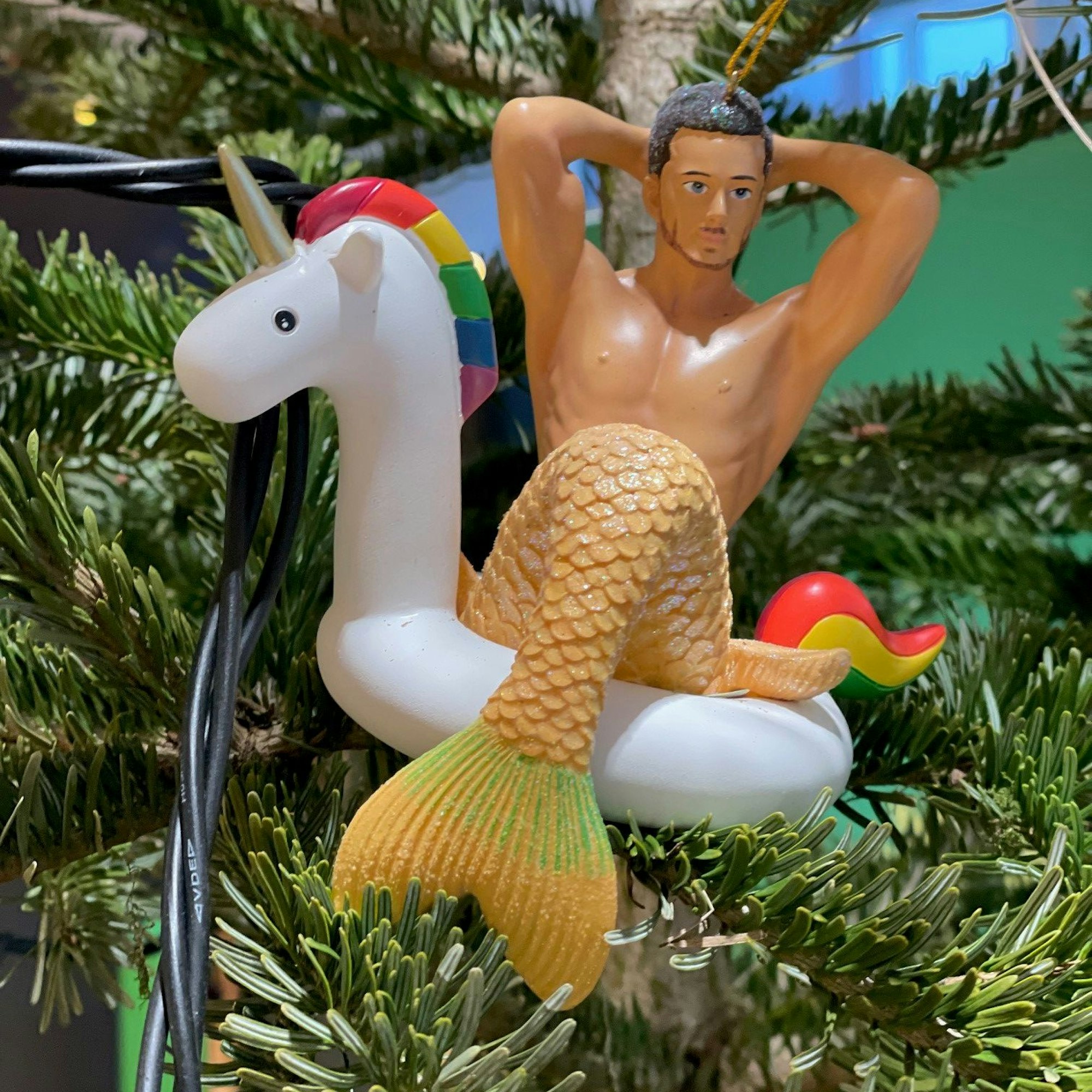 Ein Meerjungmann auf einem Regenbogen-Einhorn ist als Baumschmuck zu sehen.