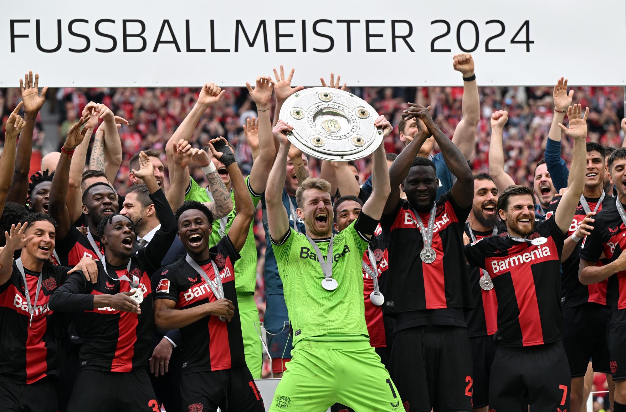 18.05.2024, Nordrhein-Westfalen, Leverkusen: Fußball, Bundesliga, Bayer Leverkusen - FC Augsburg, 34. Spieltag, BayArena, Leverkusens Torwart Lukas Hradecky (M) jubelt mit der Meisterschale. WICHTIGER HINWEIS: Gemäß den Vorgaben der DFL Deutsche Fußball Liga bzw. des DFB Deutscher Fußball-Bund ist es untersagt, in dem Stadion und/oder vom Spiel angefertigte Fotoaufnahmen in Form von Sequenzbildern und/oder videoähnlichen Fotostrecken zu verwerten bzw. verwerten zu lassen. +++ dpa-Bildfunk +++ Foto: Federico Gambarini/dpa - WICHTIGER HINWEIS: Gemäß den Vorgaben der DFL Deutsche Fußball Liga bzw. des DFB Deutscher Fußball-Bund ist es untersagt, in dem Stadion und/oder vom Spiel angefertigte Fotoaufnahmen in Form von Sequenzbildern und/oder videoähnlichen Fotostrecken zu verwerten bzw. verwerten zu lassen. +++ dpa-Bildfunk +++