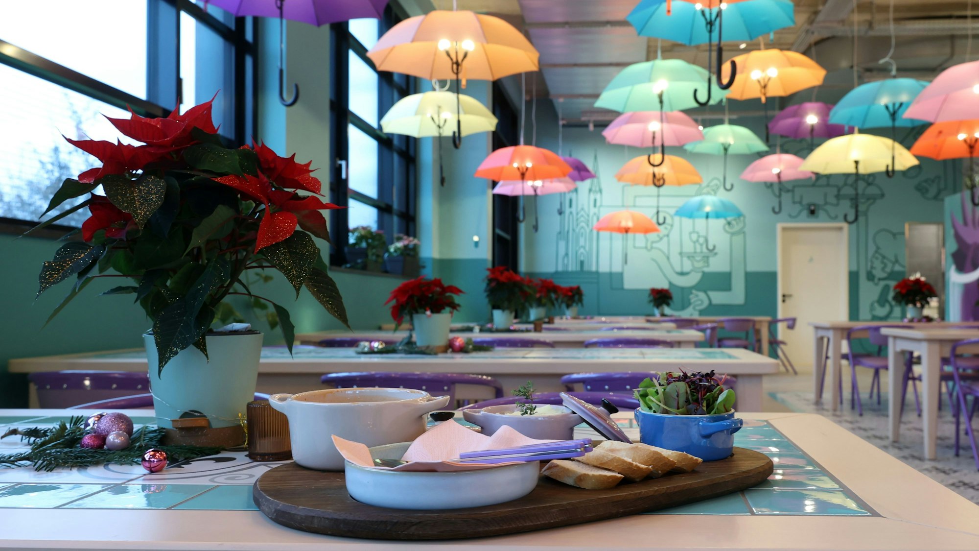 Das Restaurant Coq au Vin in Köln ist bunt eingerichtet, an der Decke baumeln bunte Schirme.