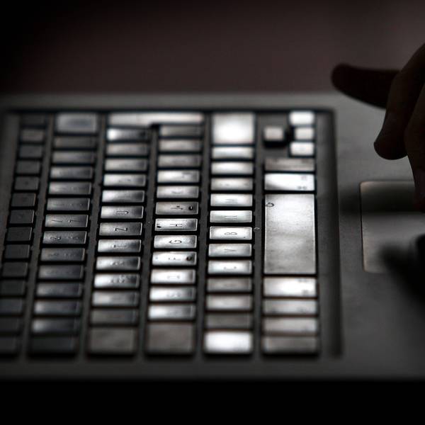 Finger einer Person arbeiten an einem Laptop