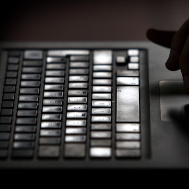 Finger einer Person arbeiten an einem Laptop