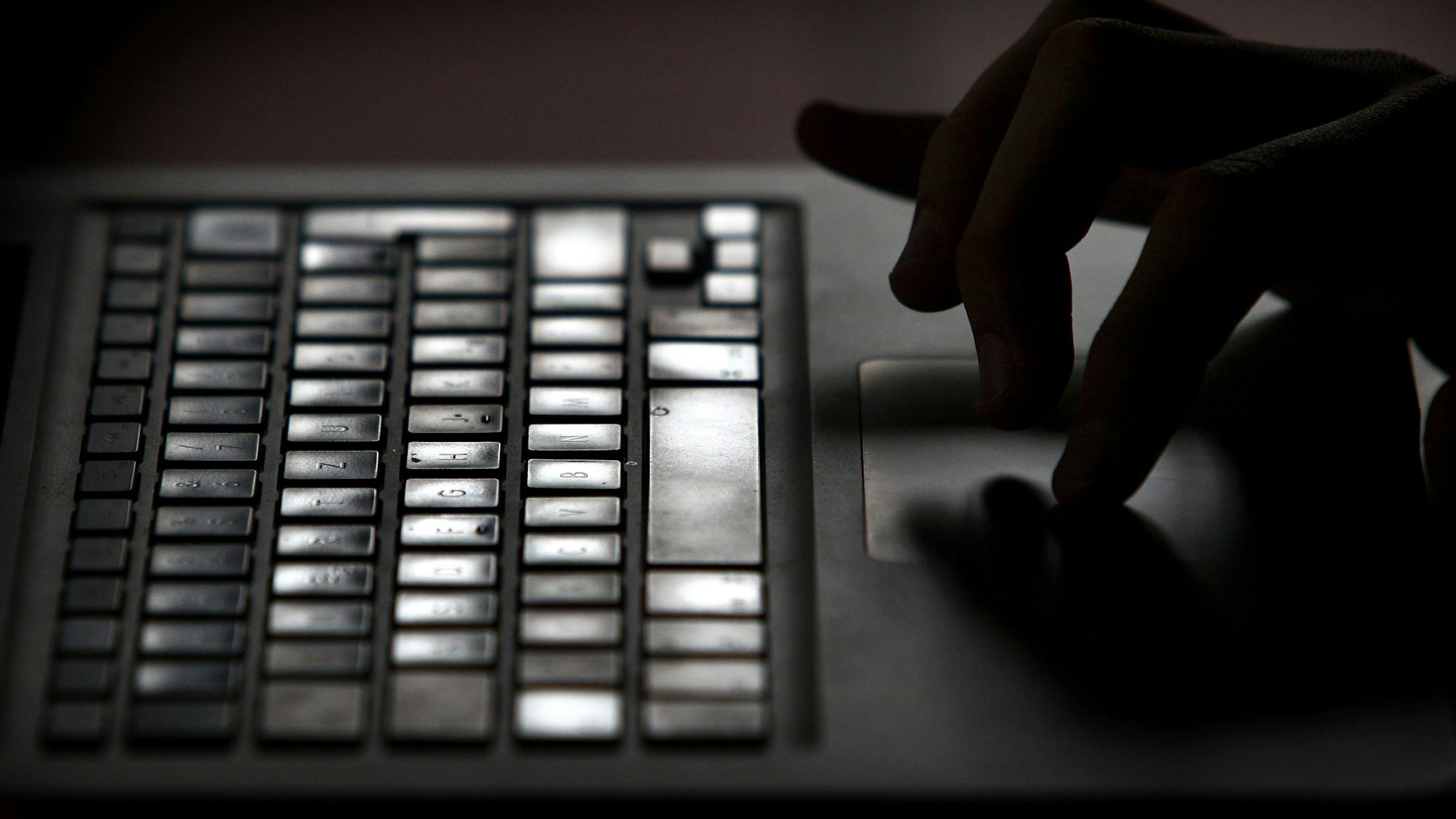 Finger einer Person arbeiten an einem Laptop