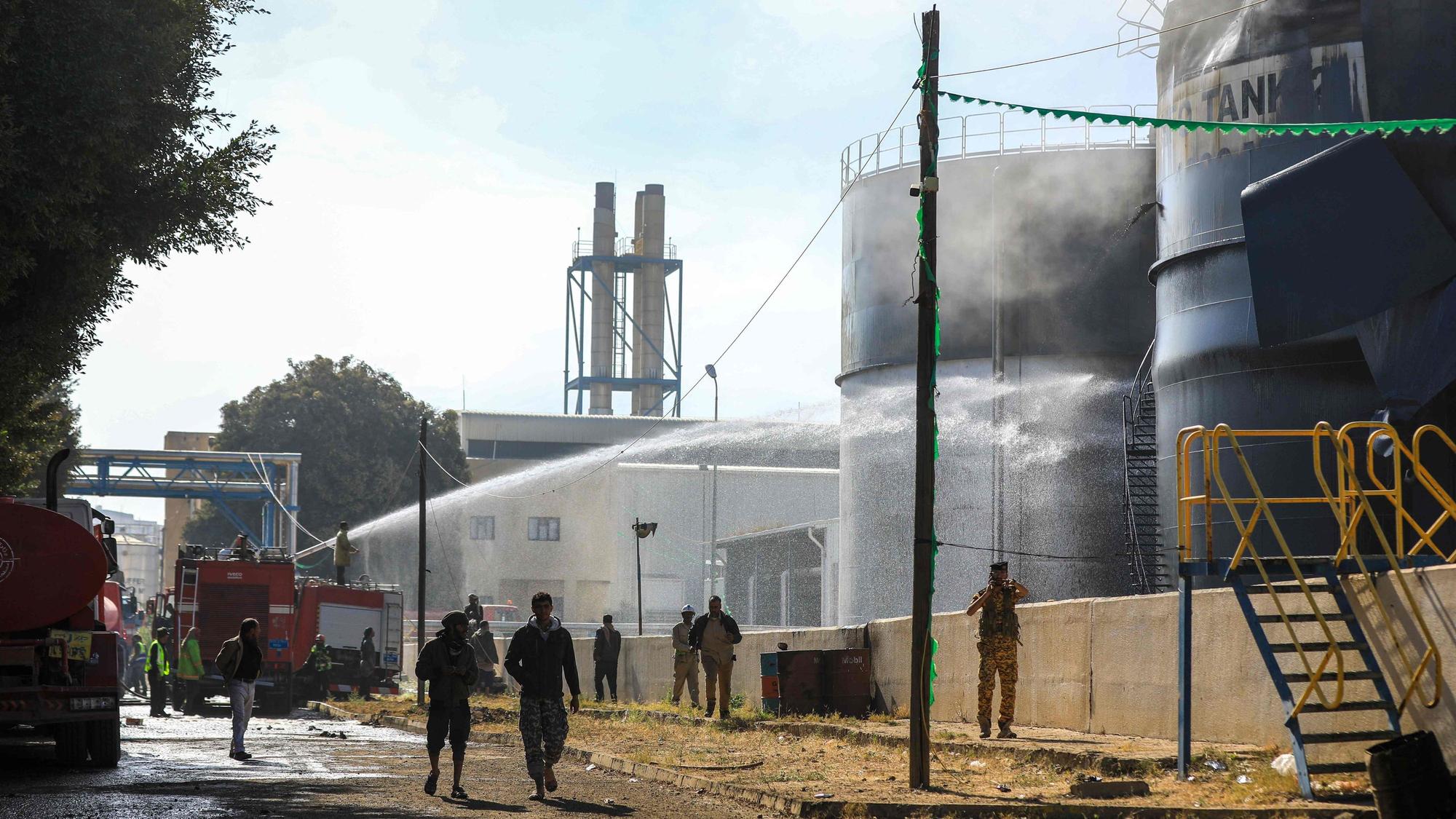 Jemenitische Feuerwehrleute löschen Öltanks mit Wasser in einem Kraftwerk, das bei einem israelischen Luftangriff in der von den Huthi regierten Hauptstadt Sanaa getroffen wurde.