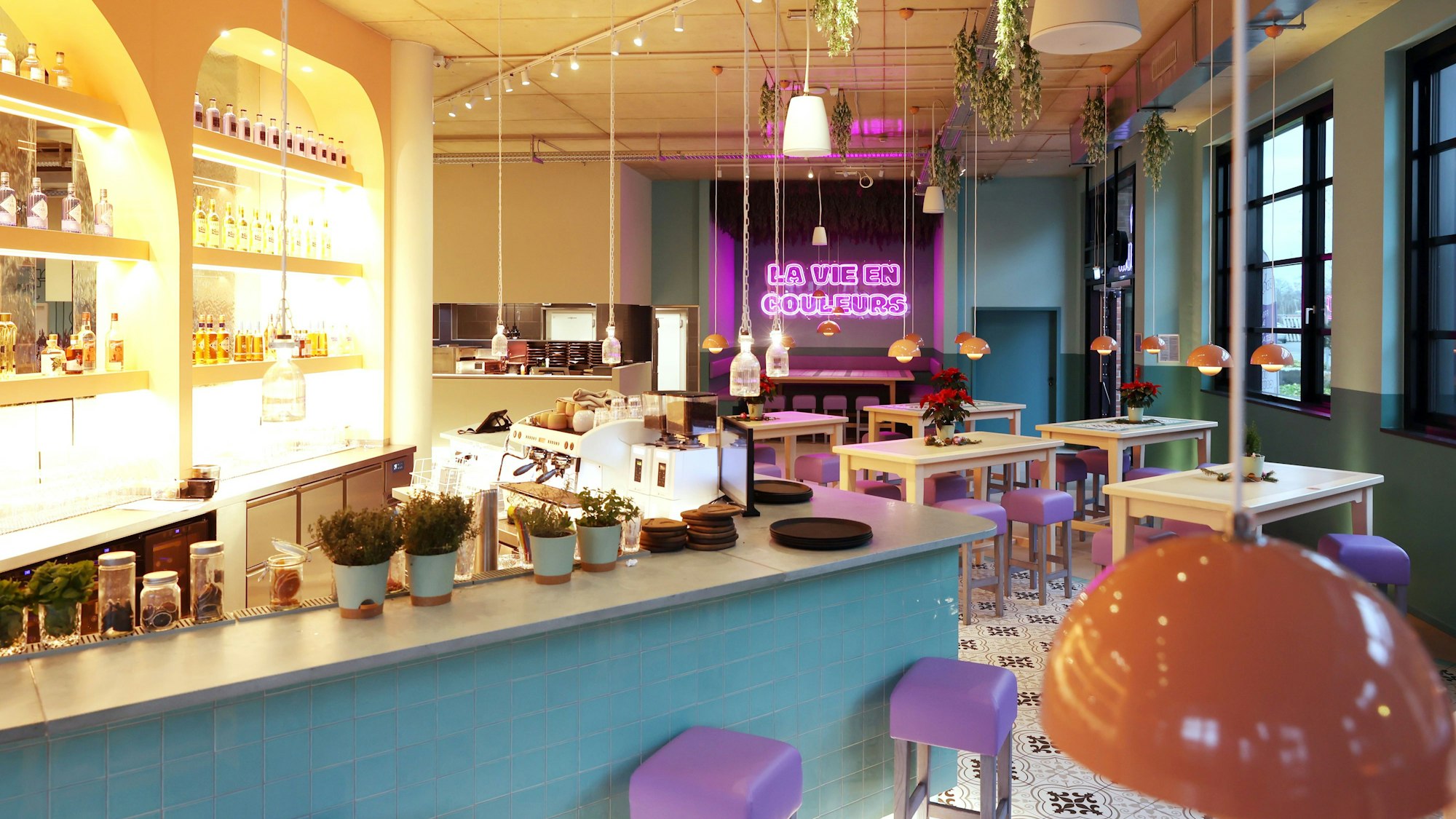 Das Restaurant Coq au Vin in Mülheim von innen mit Theke, lila Stühlen und schönem Fliesenboden.