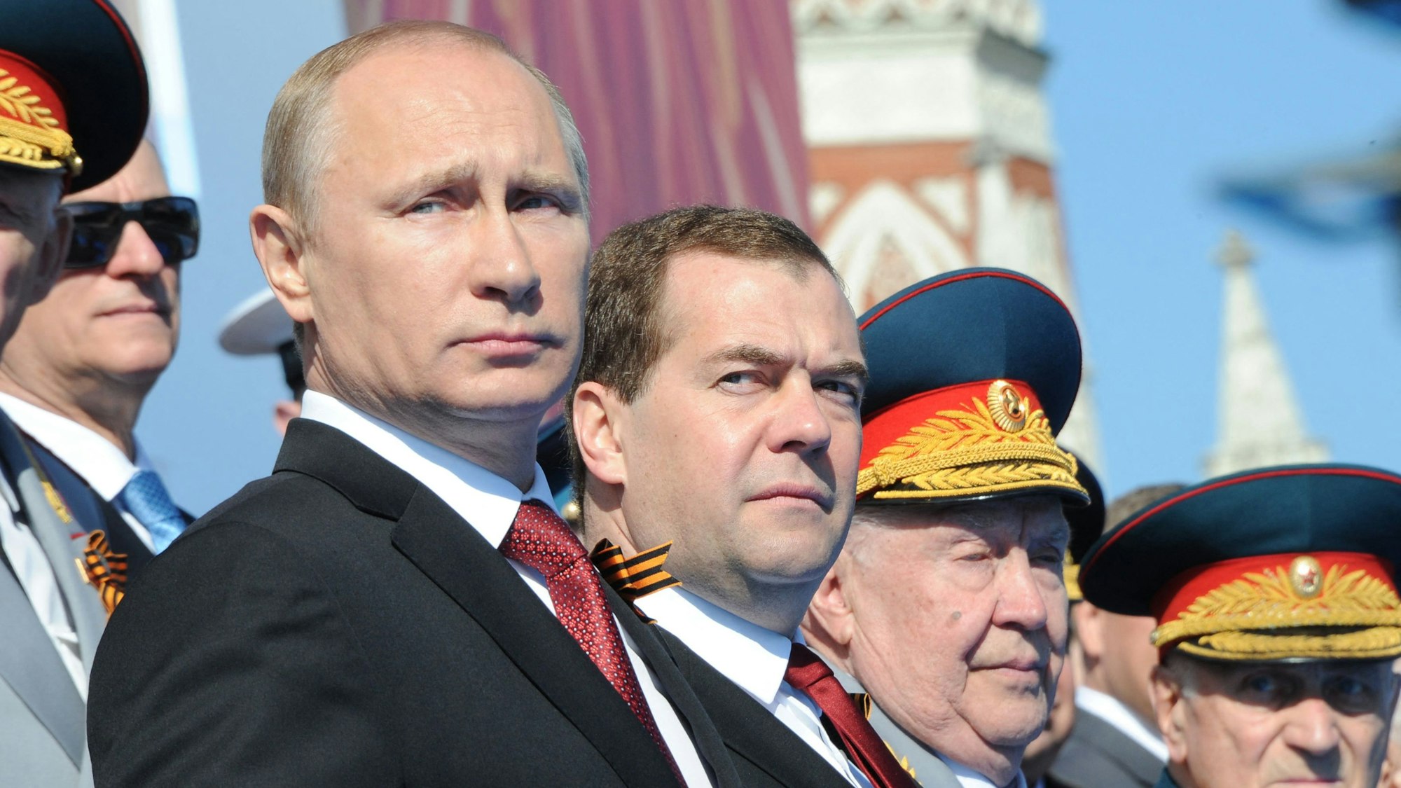 Kremlchef Wladimir Putin (l.) zusammen mit Ex-Präsident Dmitri Medwedew (M.) bei einer Militärparade. Medwedew hat mit wüsten Worten auf ein Interview des ukrainischen Präsidenten Wolodymyr Selenskyj reagiert. (Archivbild)