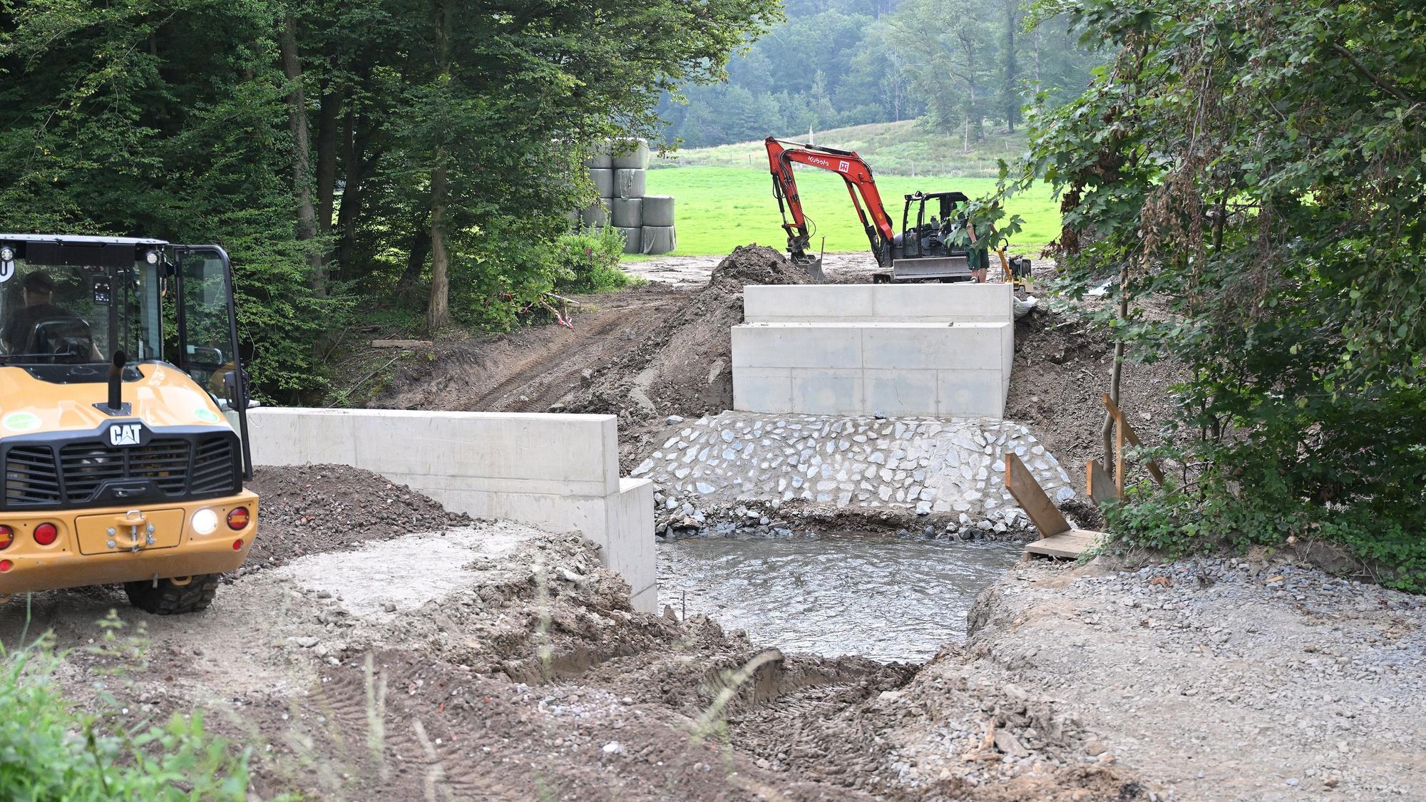 An einem Fluss wird eine Brücke gebaut.