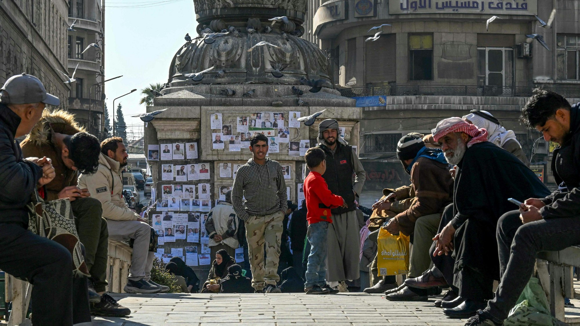 Menschen sitzen auf einem Platz in Damaskus zusammen.
